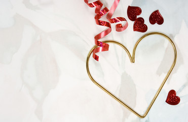 Hearts Background – A gold heart, with smaller red hearts and red ribbon on a pastel flower...