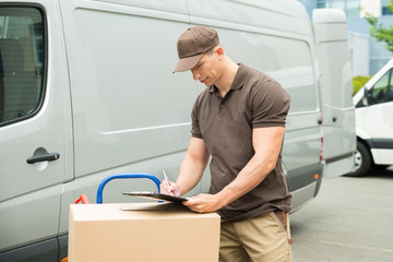 Delivery Man Writing On Clipboard