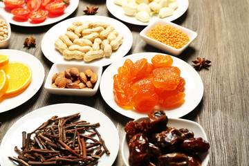 Different products on saucers on wooden table, closeup