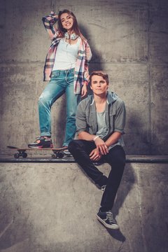 Young couple with skateboard outdoors