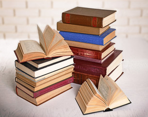 Heap of old books on brick wall background