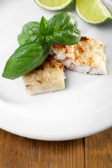 Dish of fish fillet with basil and lime on table close up