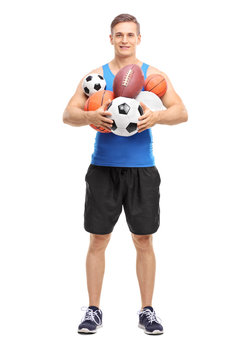 Athlete holding a bunch of different sports balls
