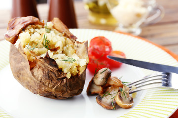 Baked potato with cheese and mushrooms on plate close up