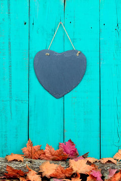 Slate heart hanging on fence with fall decor border