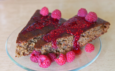 Two pieces of delicious homemade raspberry cake with jam and fresh berries