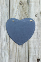 Blank slate heart hanging on wood door
