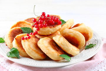 Obraz na płótnie Canvas Fritters of cottage cheese with berries in plate, closeup