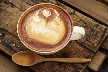 Hot mocha coffee decorated on wooden background, latte art.