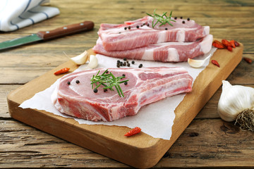 carne cruda bistecche di maiale con spezie sfondo rustico
