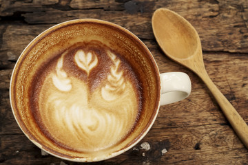 Hot mocha coffee decorated on wooden background, latte art.