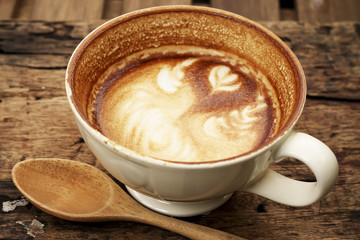 Hot mocha coffee decorated on wooden background, latte art.