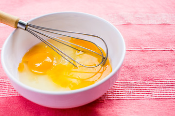 preparing omelet with eegs and whisk