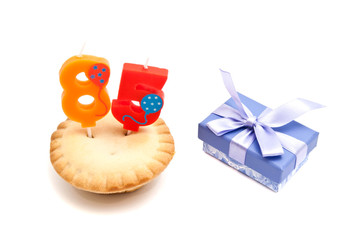 cupcake with eighty five years birthday candle and gift