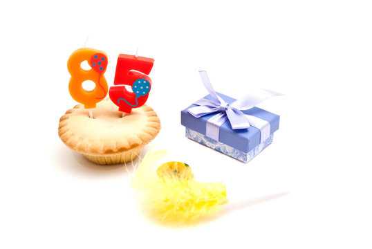 cupcake with eighty five years birthday candle, gift and whistle