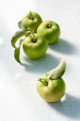 Green unripe apples with leaf