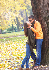 Cheerful young couple enjoy break on sunny autumn day in park