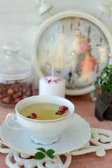 Cup of healthy green tea with dried roses