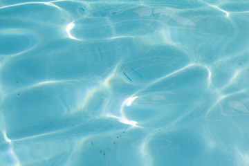 Blue pool water with sun reflections
