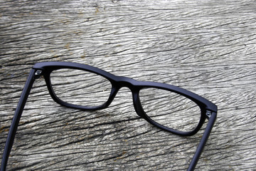 black eye glasses on wood background