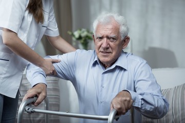 Physiotherapist helping disabled senior man