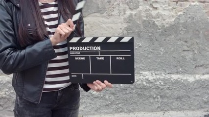 Young brunette woman with cinema clapper board