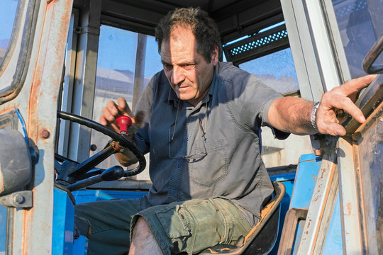 man closes door farm tractor