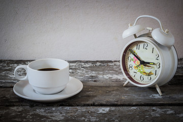 Coffee and clock on the wooden floor