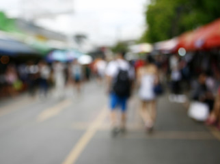 Blurred background : people shopping at market fair in sunny day