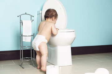 Toddler in bathroom look at the toilet