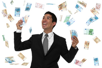 Smiling businessman holding Euro in money rain storm