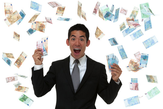 Excited businessman in a money rain storm holding Euro.