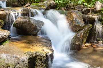 Cascading waterfall closeup very smooth water with wet rocks
