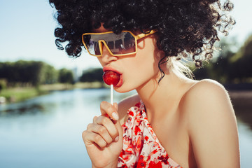 Sexy girl with black wig hair sucks lollipop