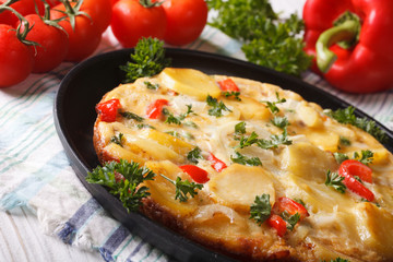 Spanish tortilla with potatoes and vegetables close-up. horizontal
