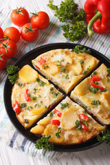 Spanish omelette with potatoes and vegetables cut into portions 
