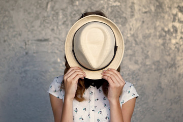 Young girl with hat. Hides her face.Depression.