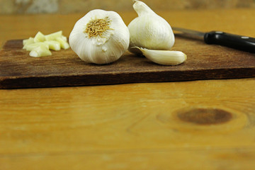 Knoblauch - Knollen, Zehe und zerhackt auf Küchenbrett mit Küchenmesser