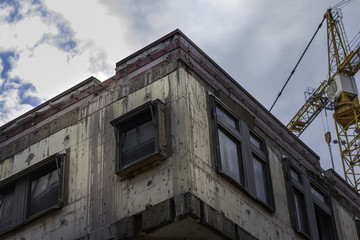 Urban concrete building being renovated with crane in the backgr