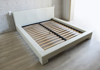 Bed in bedroom with wooden slats without mattress - obrazy, fototapety, plakaty