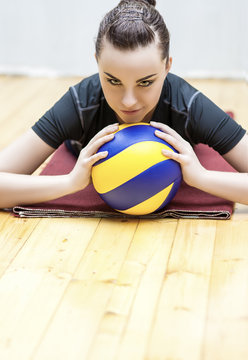 Sport and Fitness Concept. Portrait of Smiling Caucasian Volleyball Player in Professional Outfit with Ball. Vertical Image Orientation