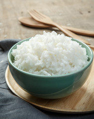 Thai jasmine rice in ceramic cup with napery and wooden spoon -