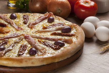 Pizza with prosciutto (parma ham) on dark wooden background top