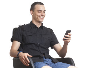 Young men using mobile phone, sitting in chair. - obrazy, fototapety, plakaty