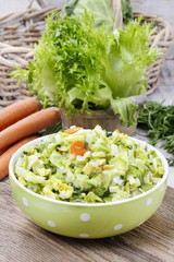 Fresh salad in green dotted bowl
