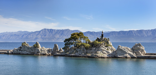 Rocks with statue of St. Mary at small adriatic port Trpanj on Peljesac peninsula in Dalmatia, Croatia - obrazy, fototapety, plakaty