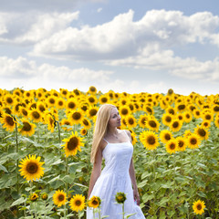 Portrait of a beautiful young blonde woman in a white dress on a