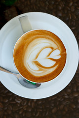 Hot coffee with heart pattern in white cup