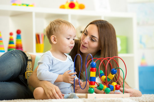 child and mother playing with educational toy
