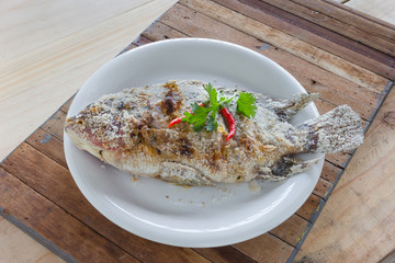 fish grilled with salt on wood background,Thai food